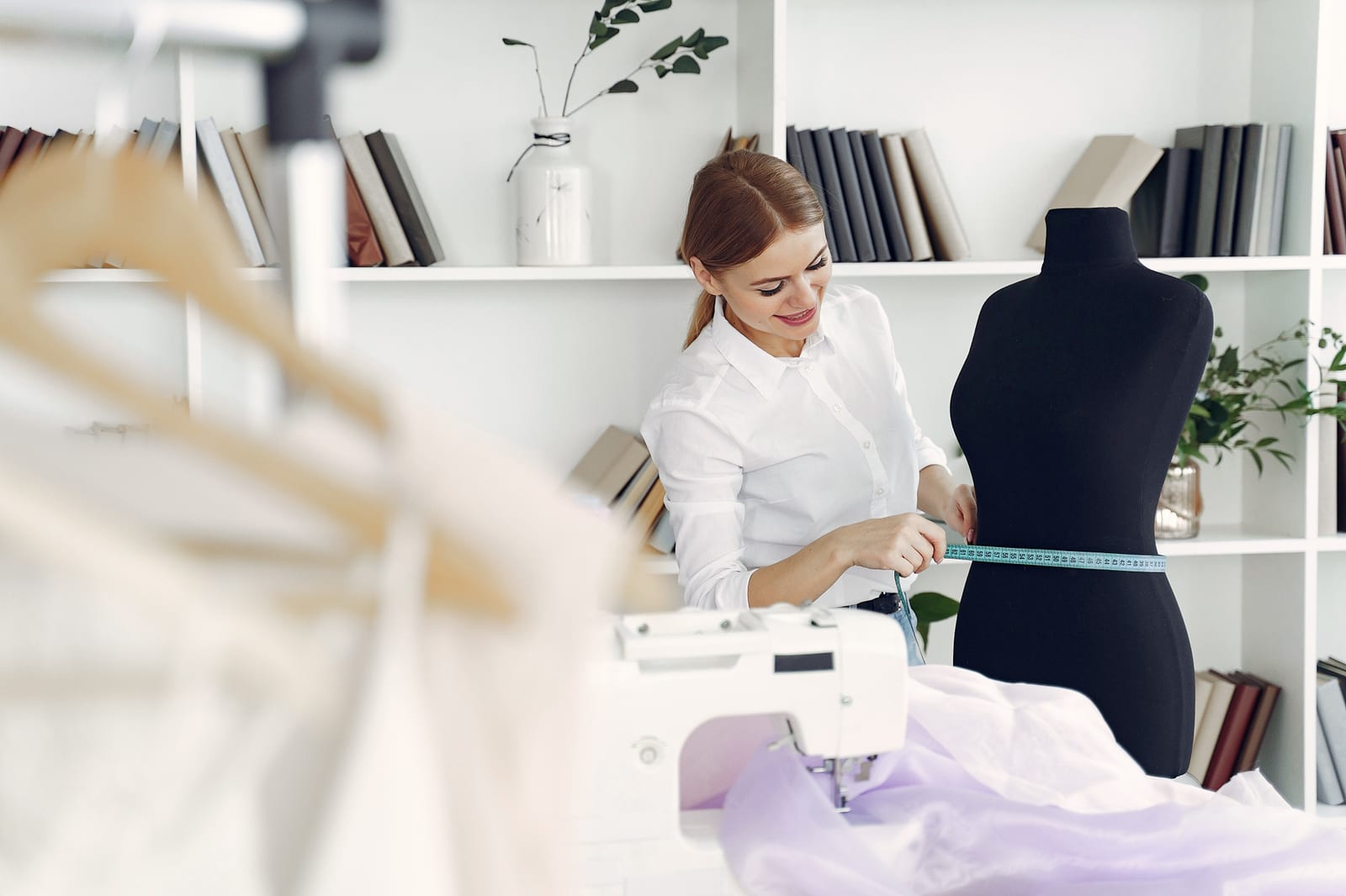Designerin arbeitet an einem Kleidungsstück im Atelier